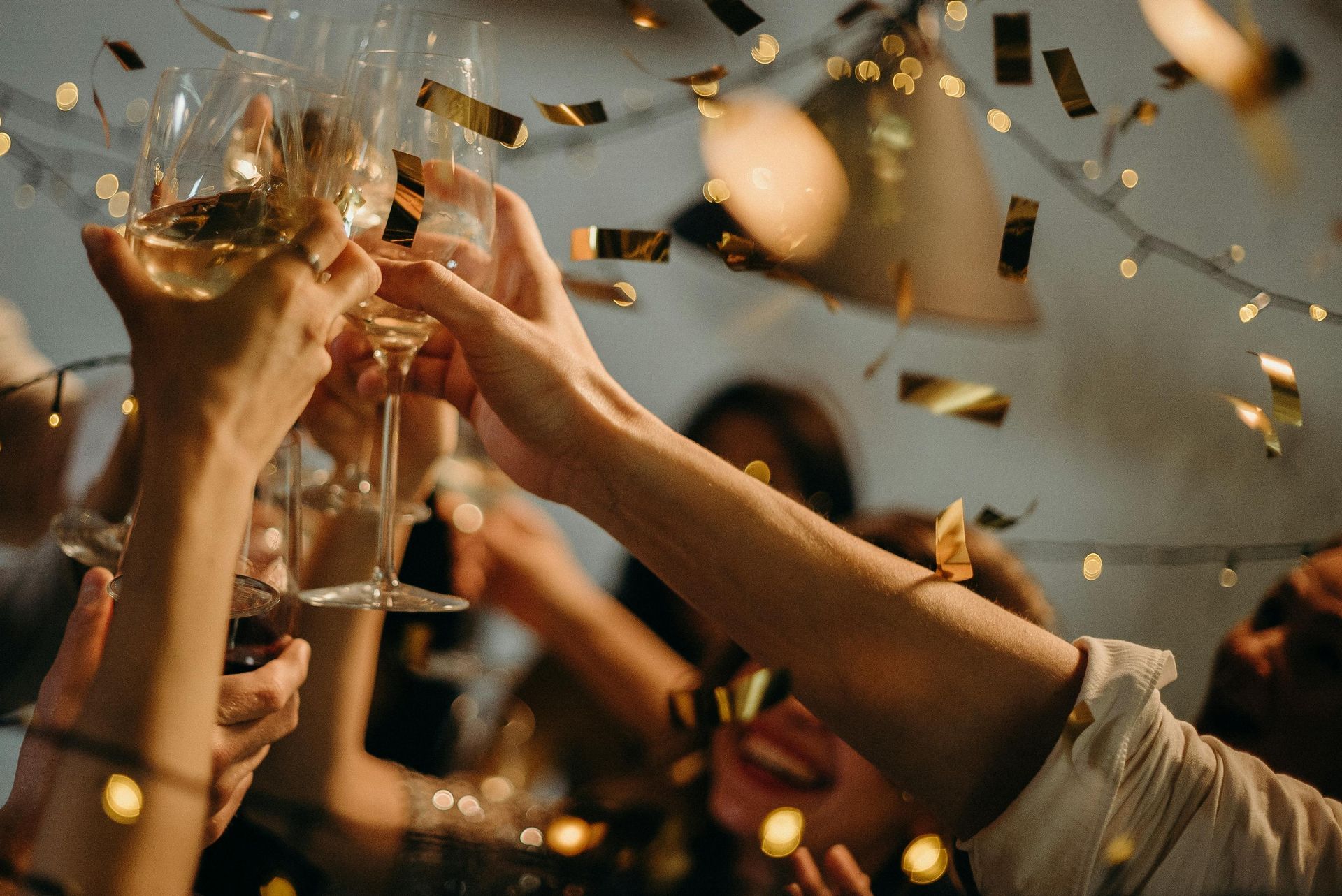 Un groupe de personnes trinquent avec des coupes de champagne lors d'une fête.